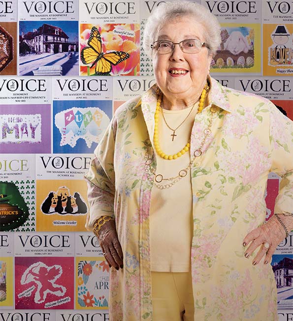 Suzanne posing in front of magazine backdrop